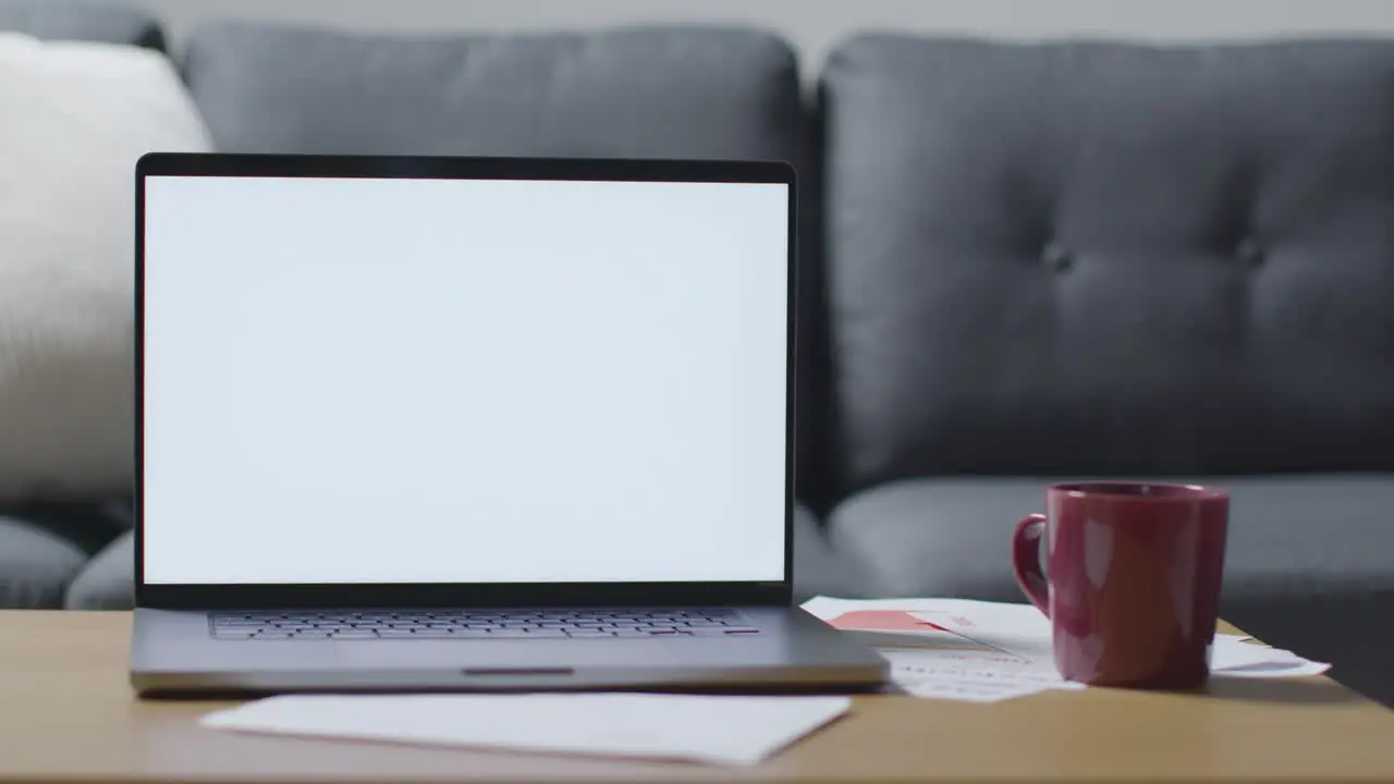 Laptop With Blank Screen On Table At Home Covered With Bills In Cost Of Living Crisis