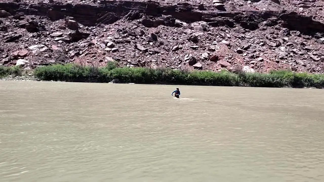 Guy walking backwards into river