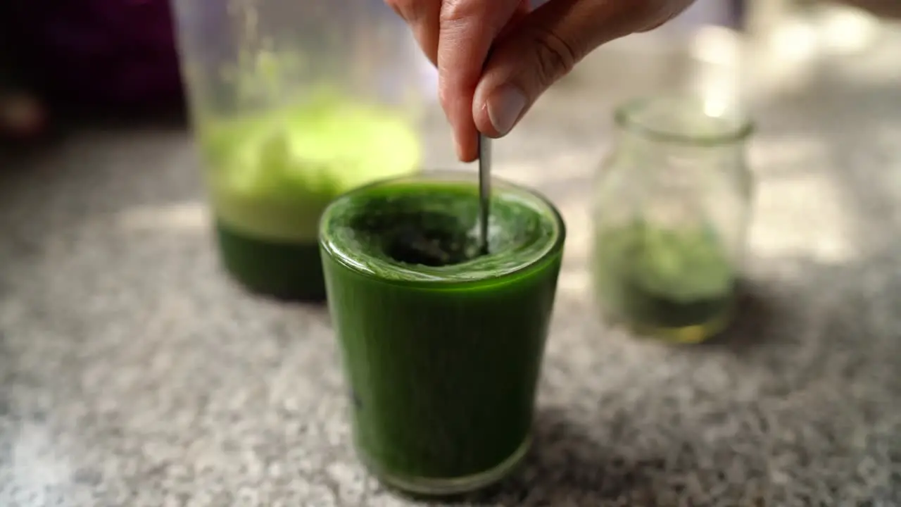 Adding Spirulina To Glass Of Healthy Green Vegetable