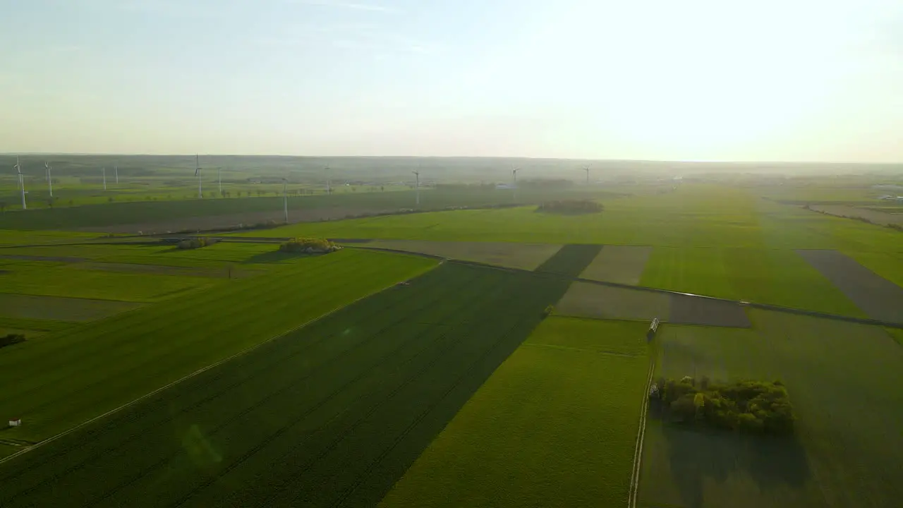 Stunning aerial view of wind turbines on the green agricultural flat fields at sunset in Puck Poland