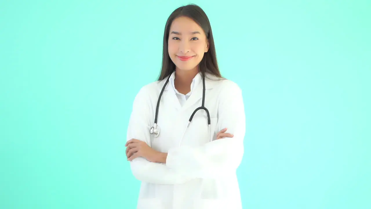 Female asian doctor standing up with arms crossed and smiling