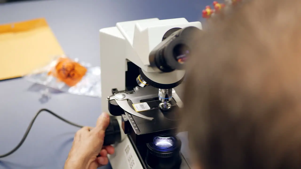 A medical lab technician examining the cancer cells from a patients biopsy to diagnose the disease in a research laboratory