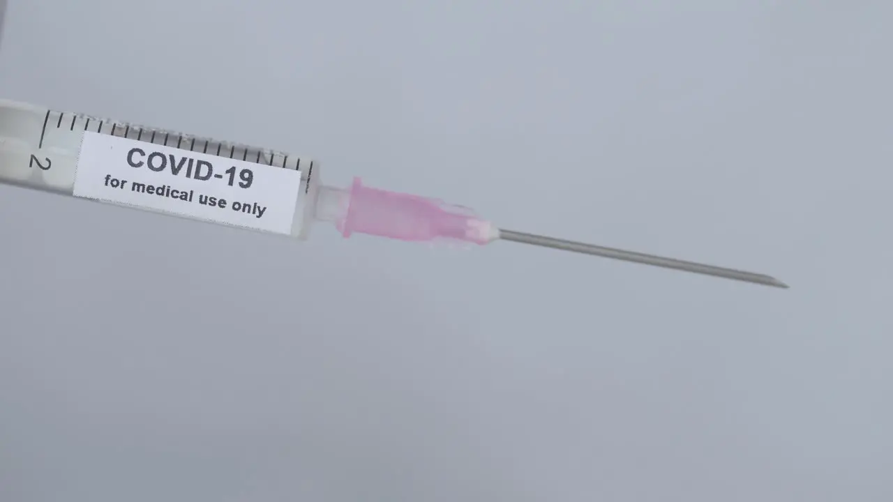 Hand With Elastic Glove Removes The Needle Cap Of Syringe With COVID-19 Vaccine For Medical Use Only