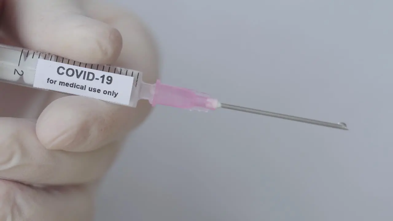 Doctor's Hand With Glove Pushes Syringe COVID-19 Vaccination close up