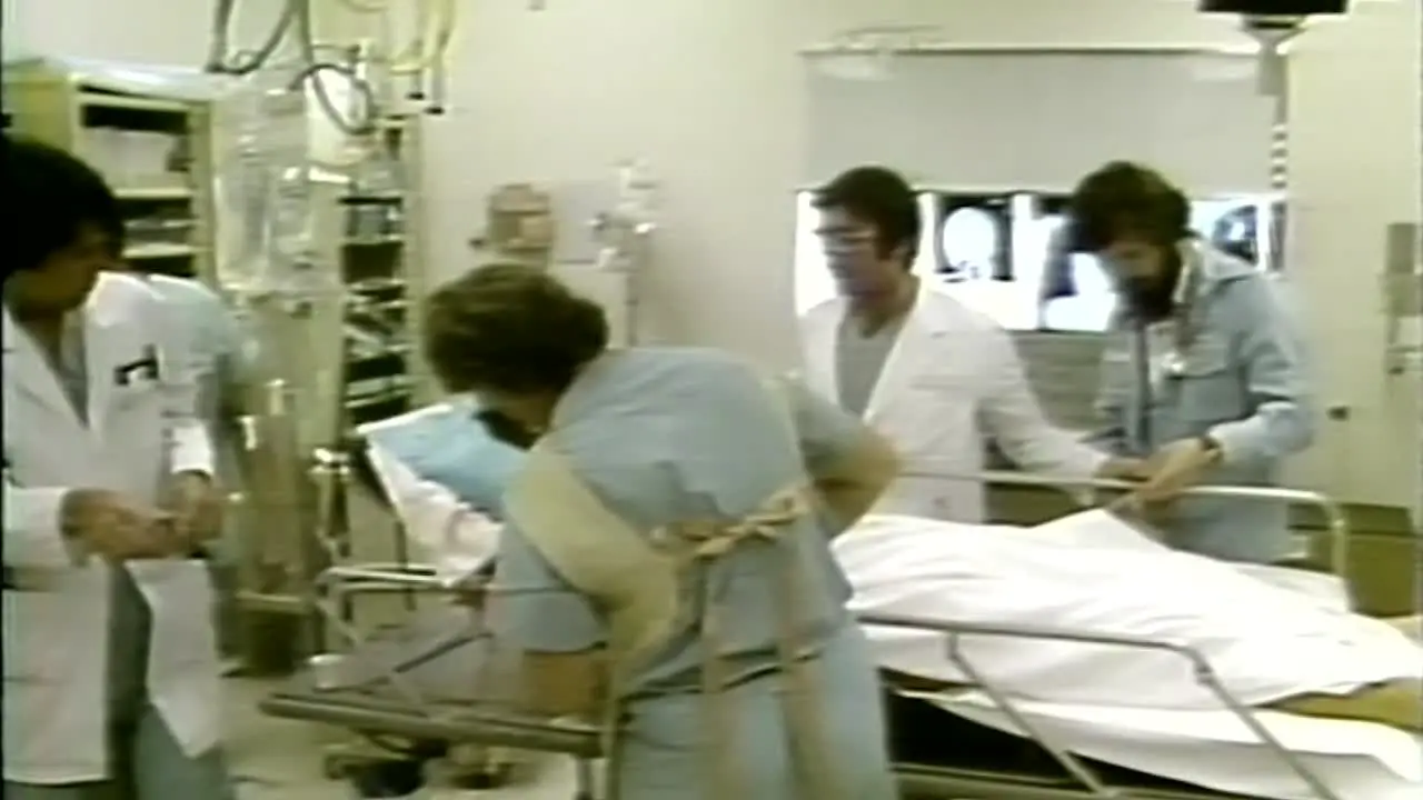 1980s DOCTORS AND NURSES HELPING PATIENT IN HOSPITAL