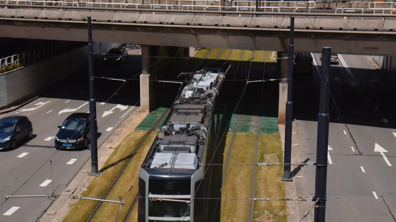 Slowmotion shot of a tram travelling under an underpass with cars driving beside Rotterdam