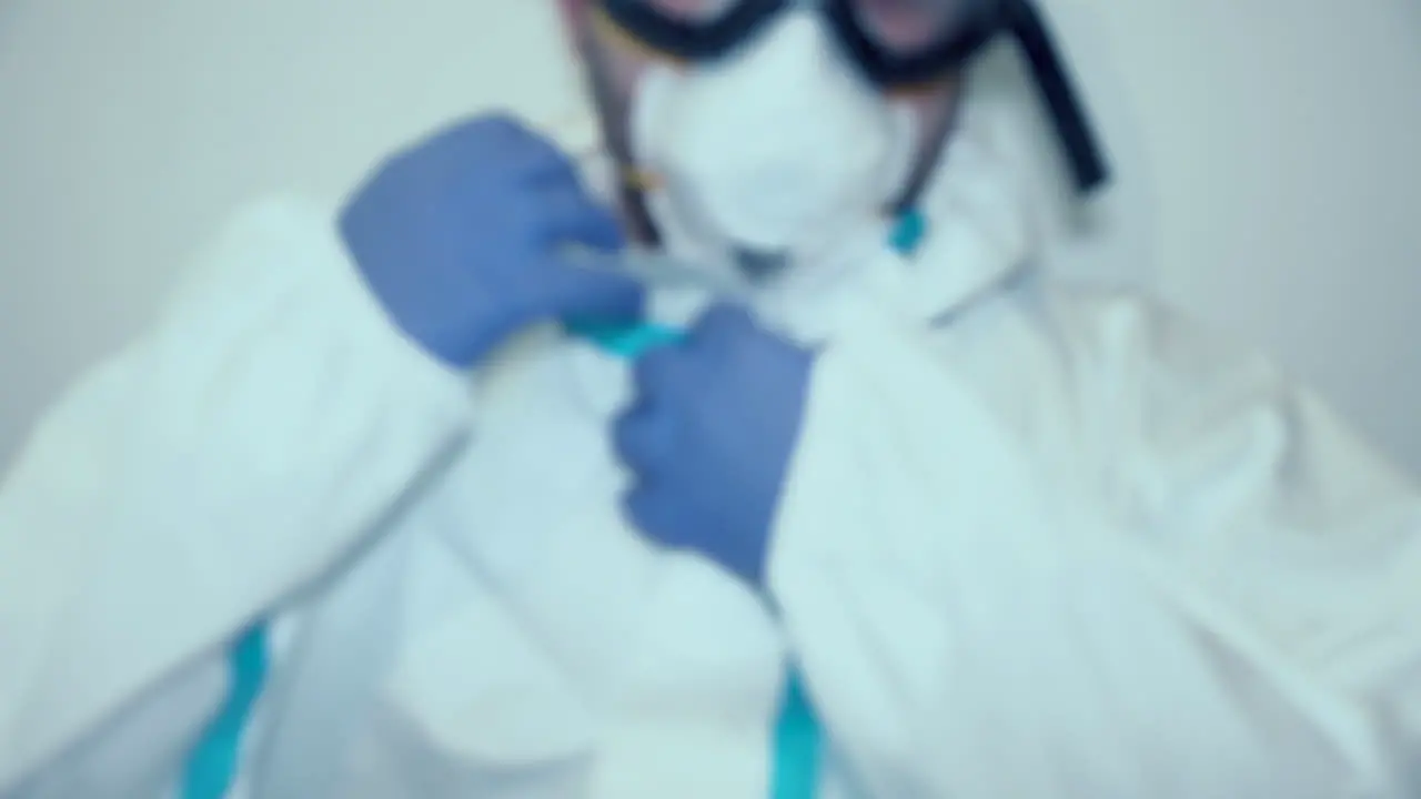 Cropped Portrait Of Medical Worker Putting On Hood Of PPE Suit Coronavirus Concept medium shot