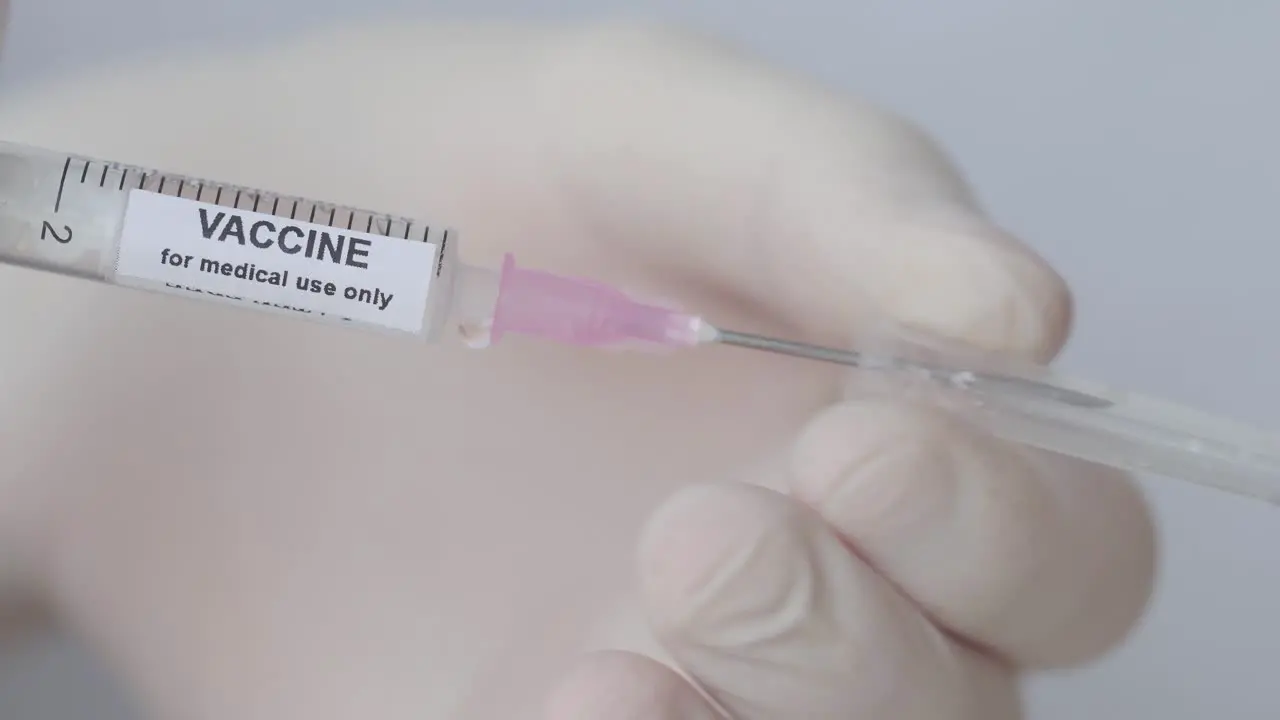 Hand Removing Cap Of Syringe Needle Vaccine for Medical Use Only close up slow motion