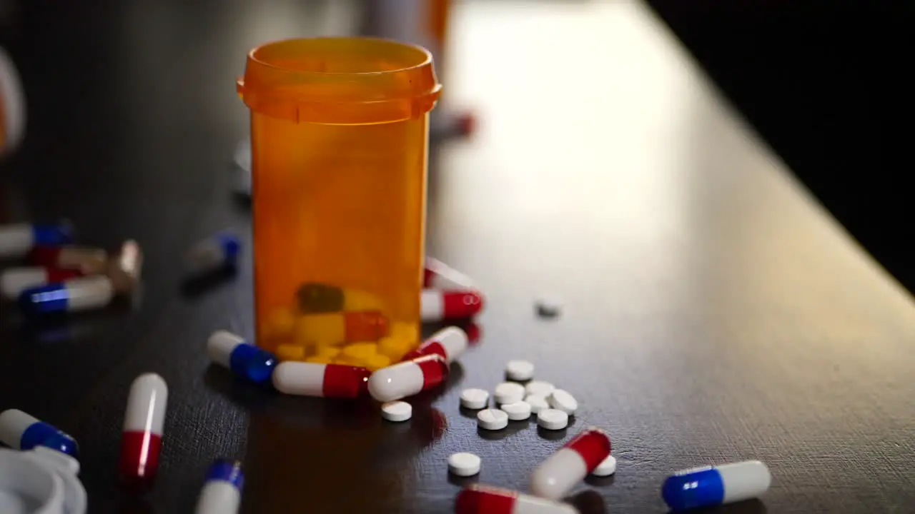 Slow motion prescription drug medication pills falling next to antibiotics and narcotics