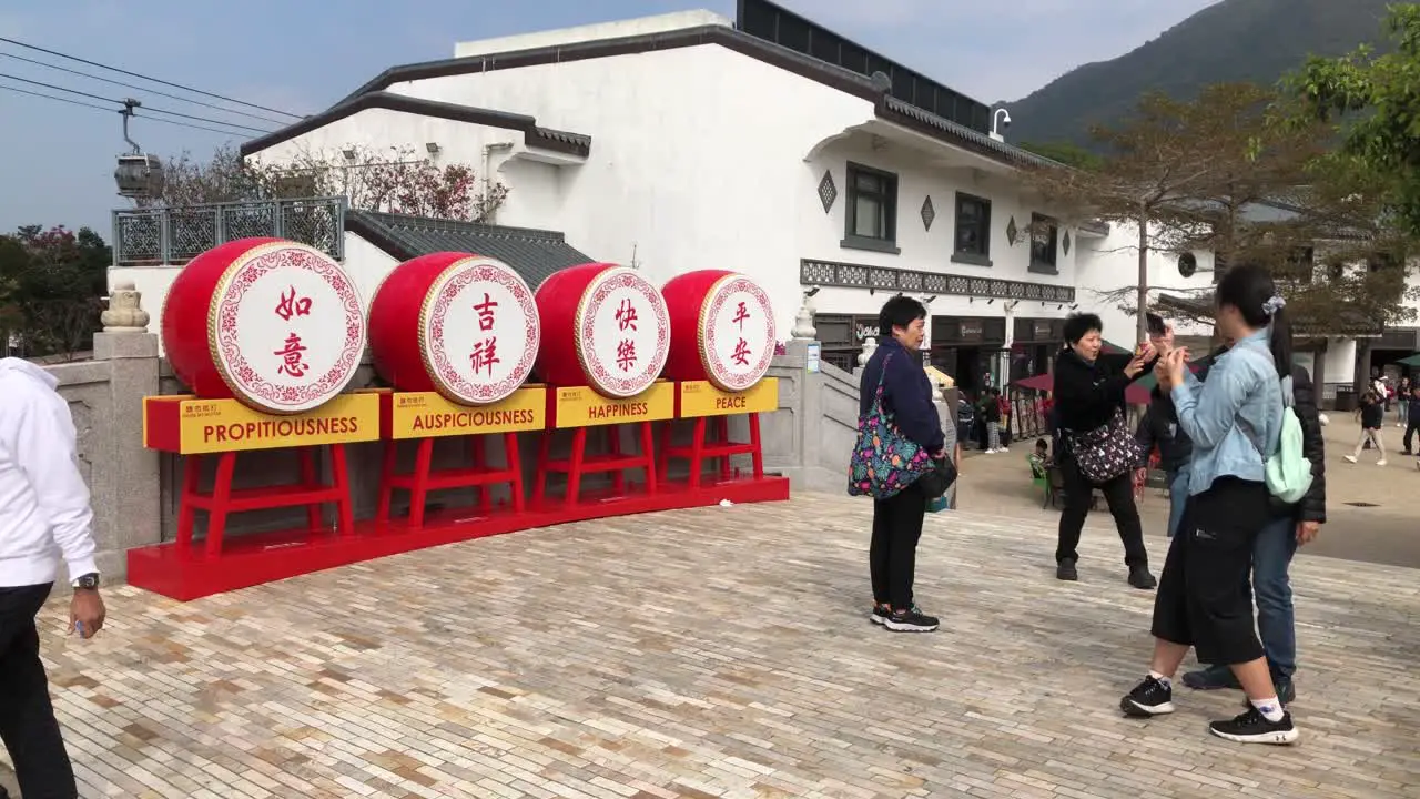 Tourists take pictures next to a display in Ngong Ping Village Hong Kong