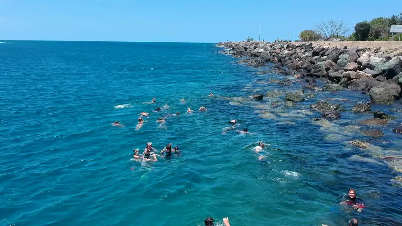 A group of children enjoying a day out swimming at a local water spot under the supervision of adults