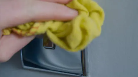 Sliding Extreme Close Up Shot of Male Hand Cleaning Light Switch On Wall