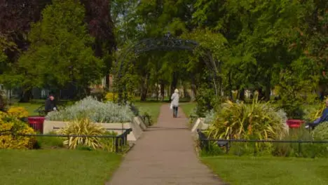 Tracking Shot of Senior Woman Walking Through Public Park