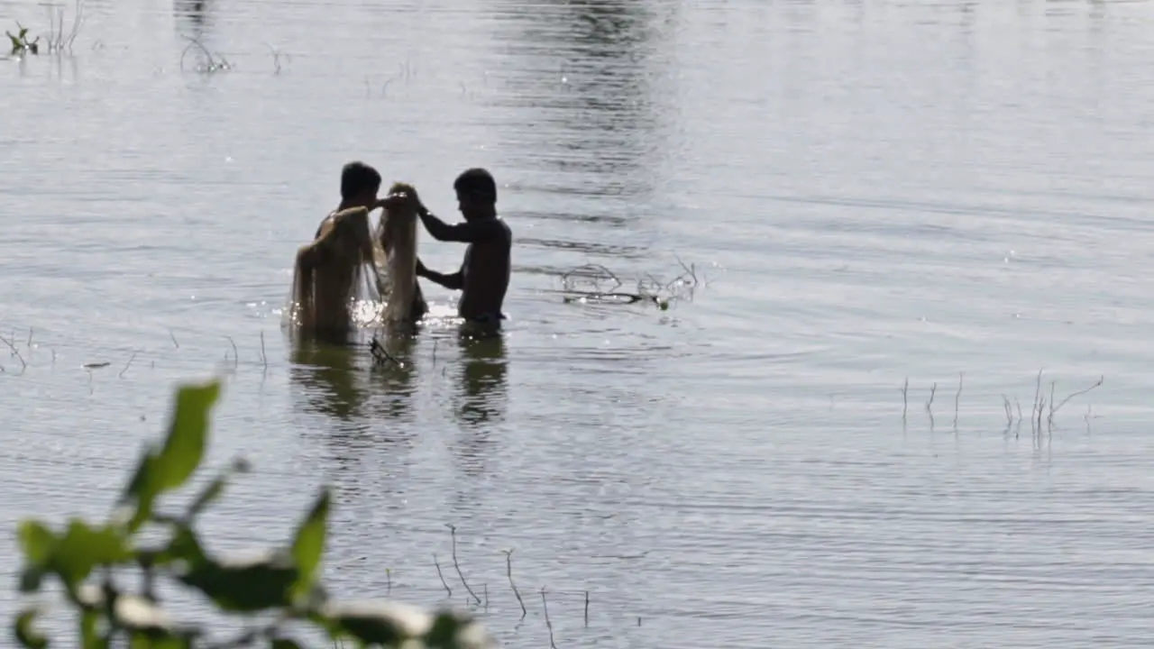 two burmese fisherman standing in a lake in myanmar