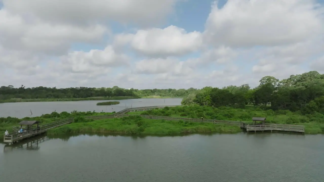 Aerial drone view people fishing and walking on the boardwalk over Armand Bayou at Bay Area Park in Pasadena Texas