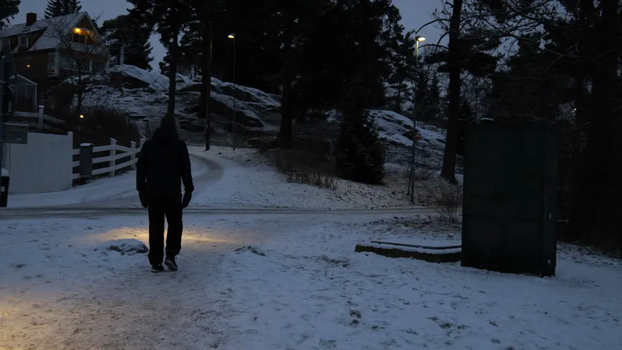 Man walking at night in a snowy village