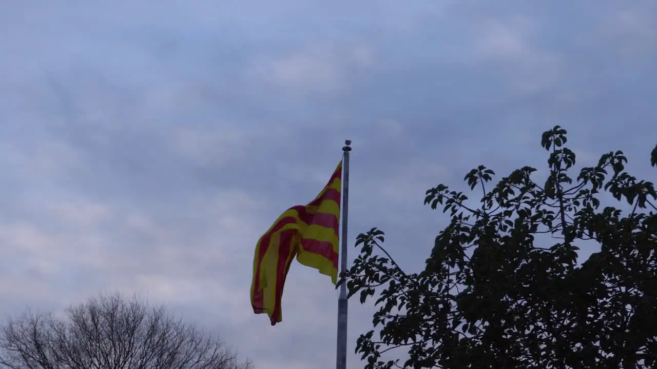 Catalonian Flag Flapping in the Wind on Montjuïc with a Patchy Sky behind