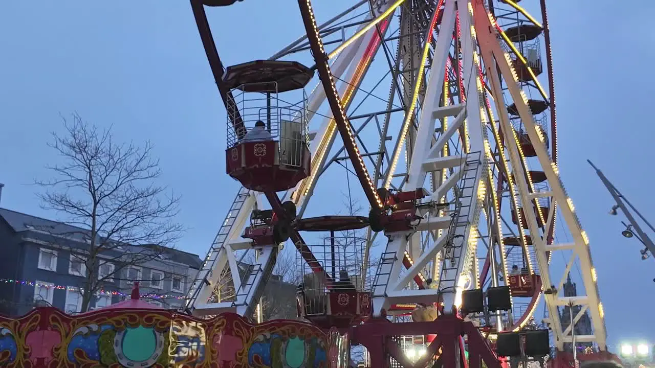 Ferris wheel slowly turning with night falling in Cork city Ireland