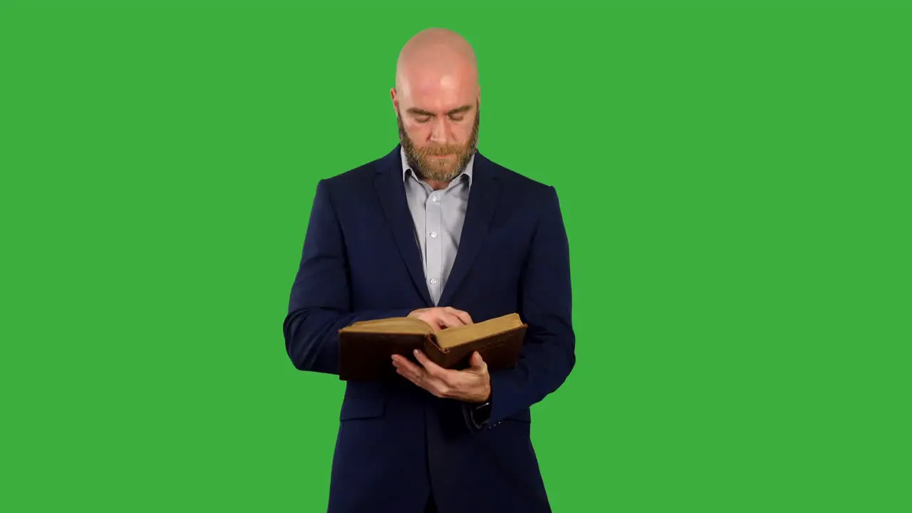 A man reading a book or bible on green screen