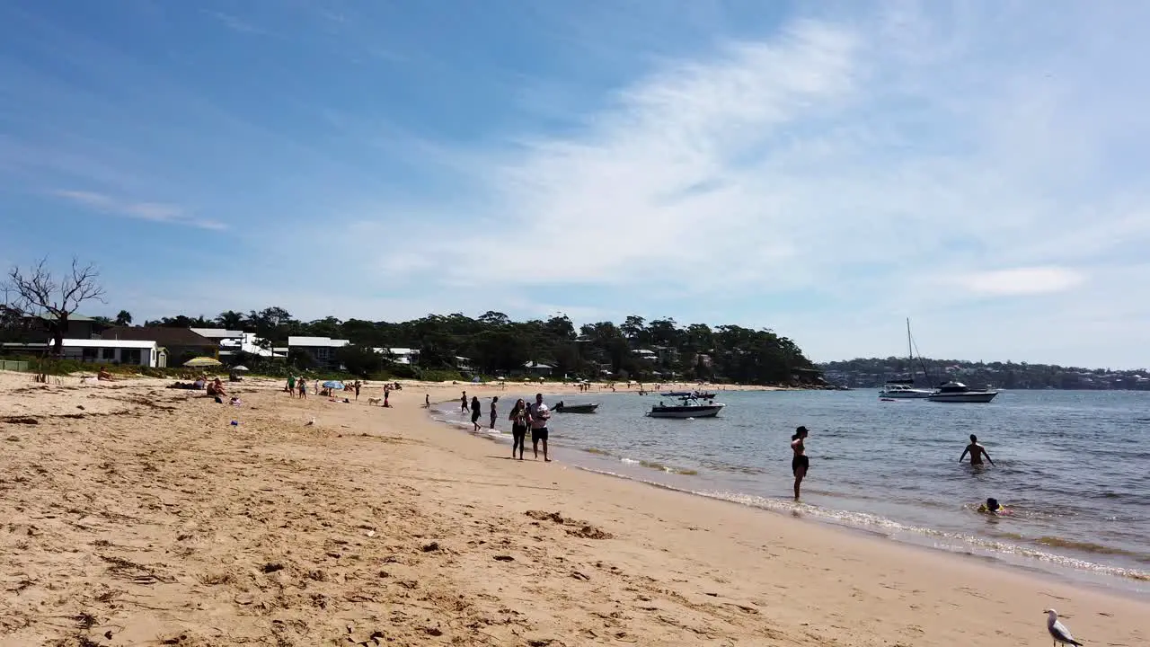 People relaxing or walking along the main beach of Bundeena near Sydney Australia