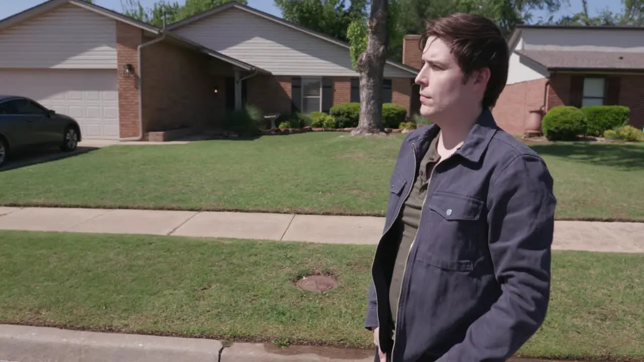 Man looks emotionally in the distance of a neighborhood