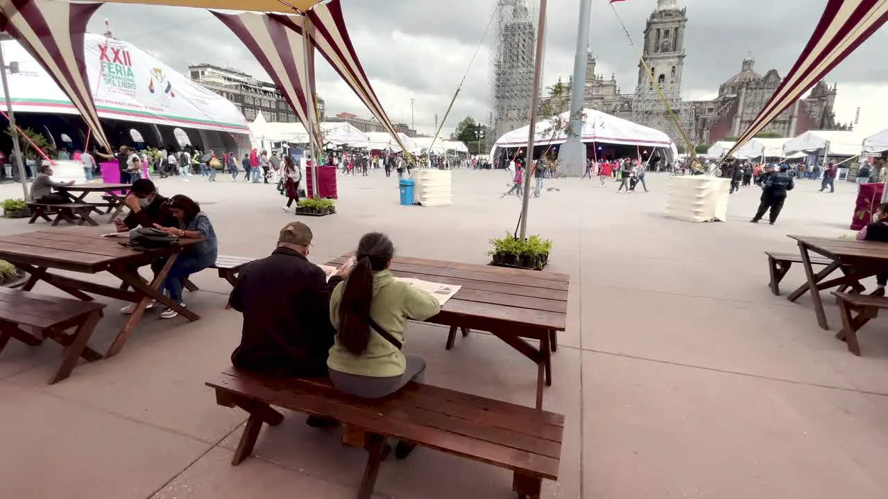 shot of couple sitting reading the newspaper in the zocalo of mexico city in the morning