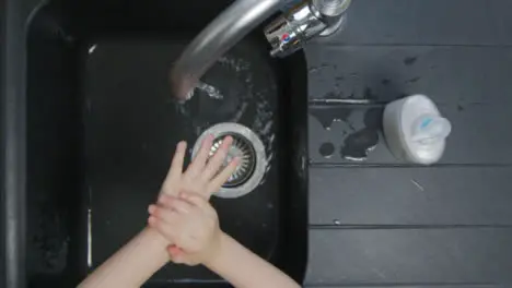 Top Down Shot of Young Childs Hands Washing Under Tao Before Turning It Off