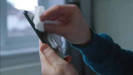 Sliding Close Up Shot of Male Hands Cleaning Phone Screen with Anti Bacterial Wipe