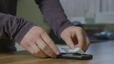 Sliding Close Up of Male Hands Cleaning Mobile Phone with Anti Bacterial Wipe