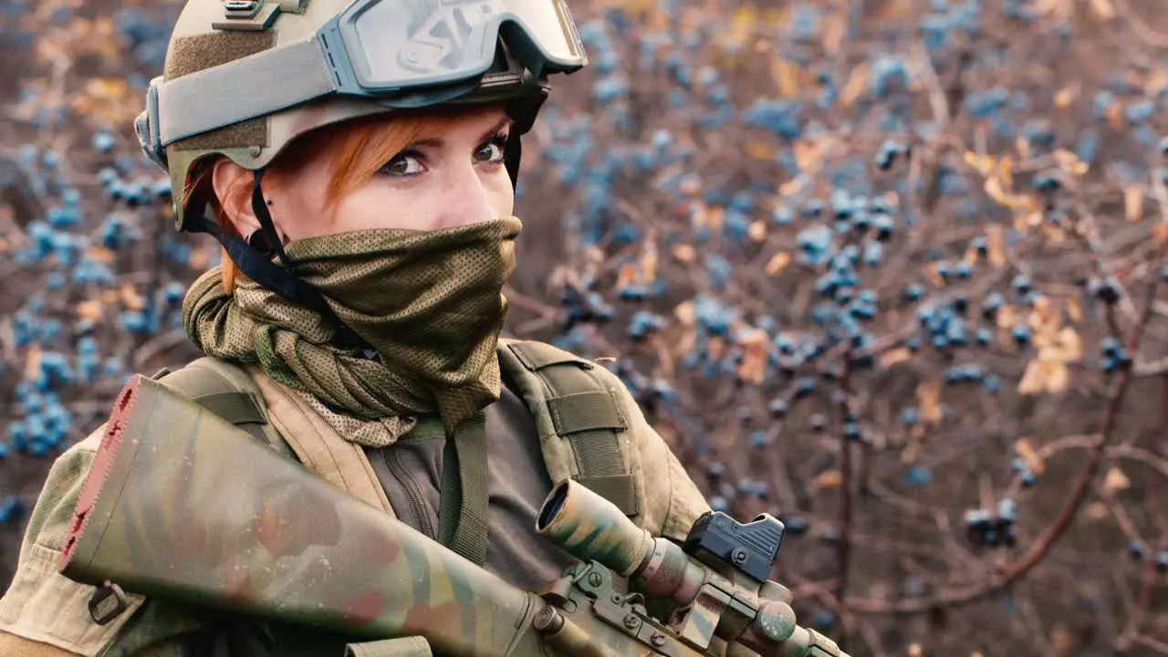 A woman in camouflage aims with a rifle 1