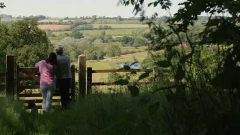 Panning Shot of Middle Aged Couple Looking Out at Countryside Valley