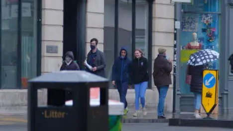 Pedestal Shot of Pedestrians Walking In Rain In City