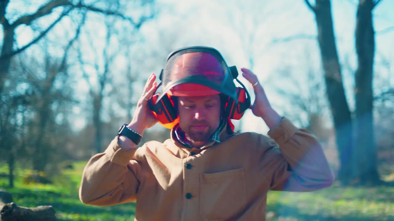 Man putting on a helmet to work in the woods