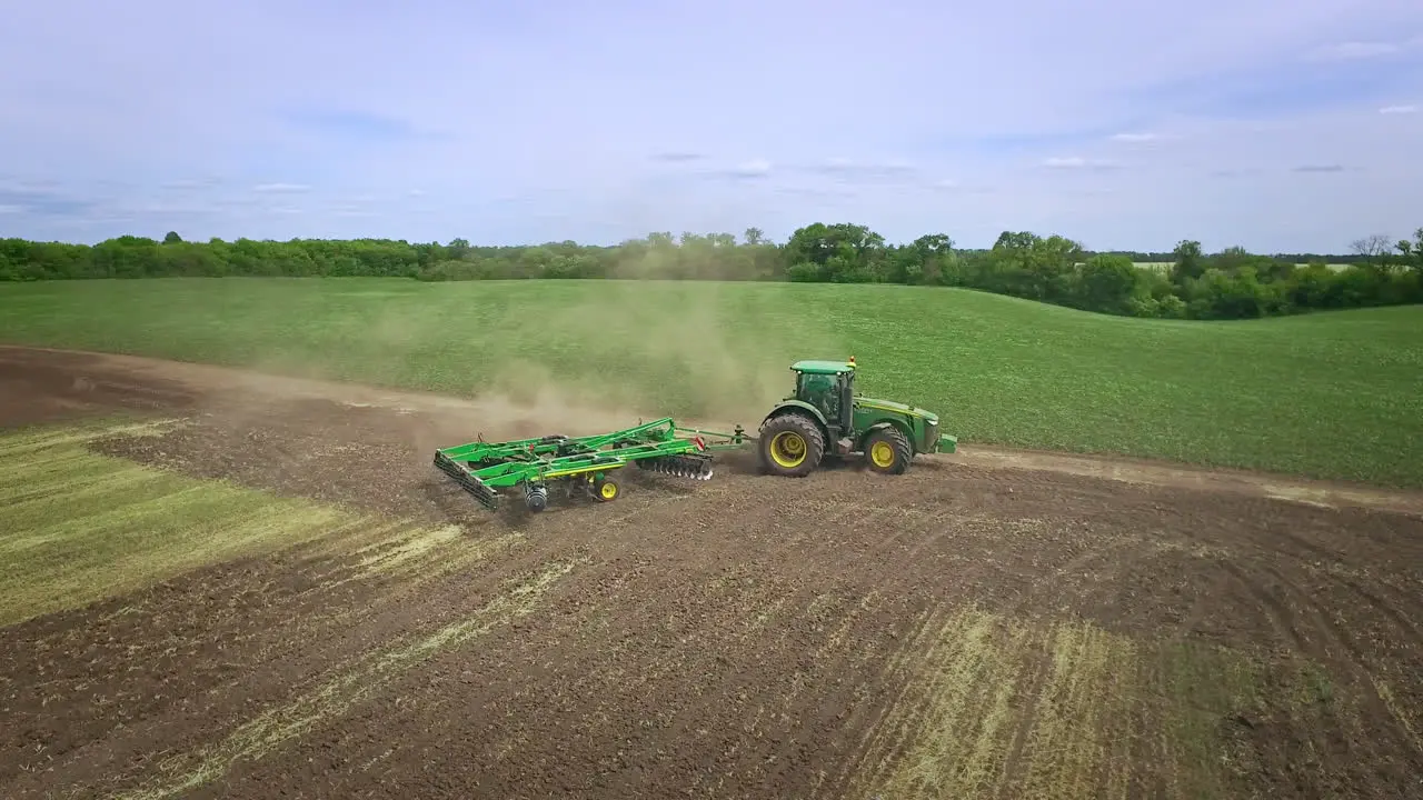 Agricultural tractor with trailer plowing agricultural field Rural farming