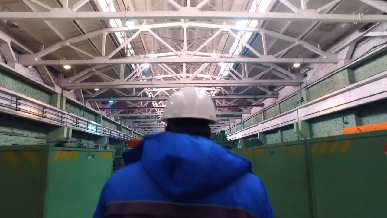 Worker walking in workshop of steel factory Engineer walking at metal factory