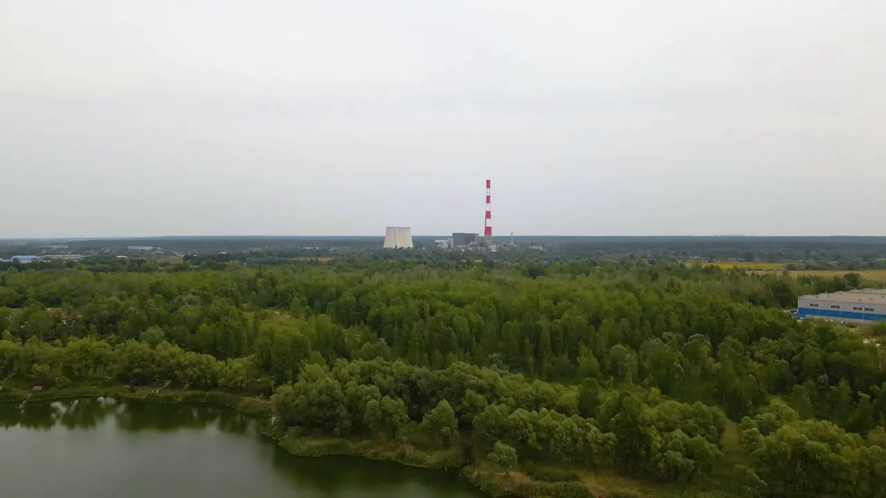 Aerial view over a river and forest towards the TES 6 coal power plant cloudy day in Kiev Ukraine dolly drone shot