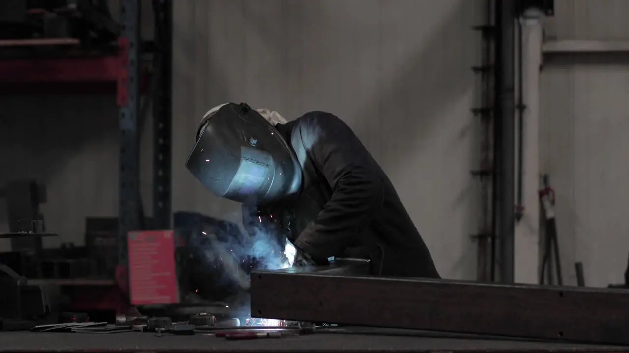 Industrial Worker In Protective Mask And Suit Welding Metal In A Factory medium shot