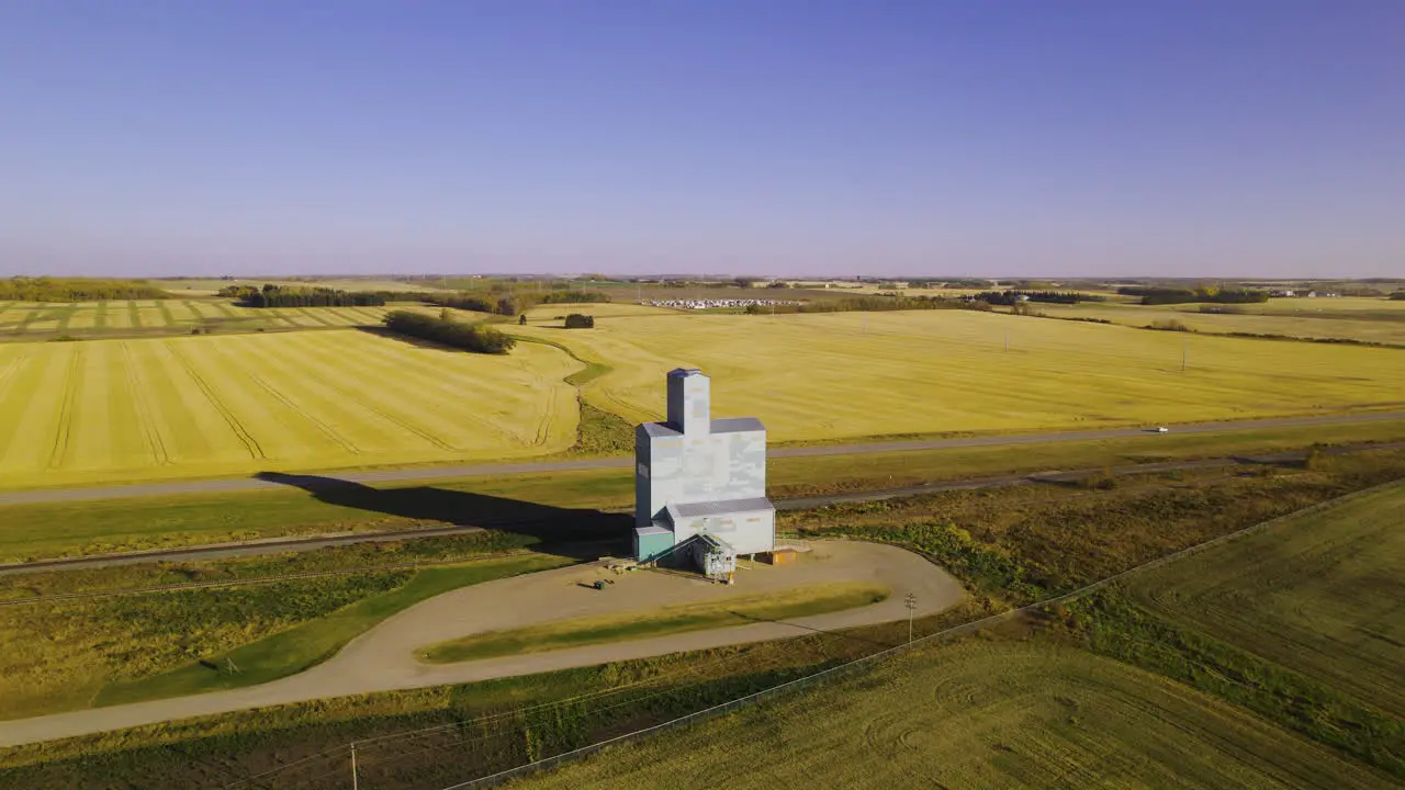 Aerial view grain elevator standing out between farm land