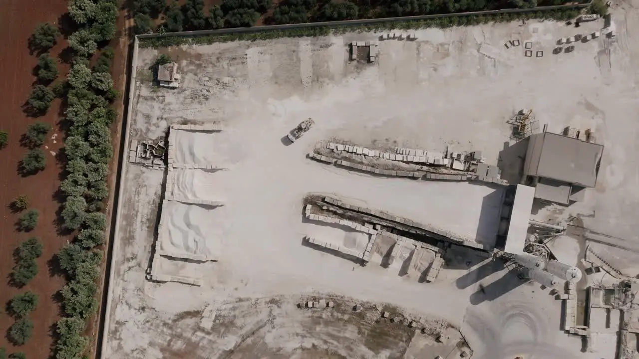 Top down aerial footage in southern Italy of a truck moving gravel back and forth