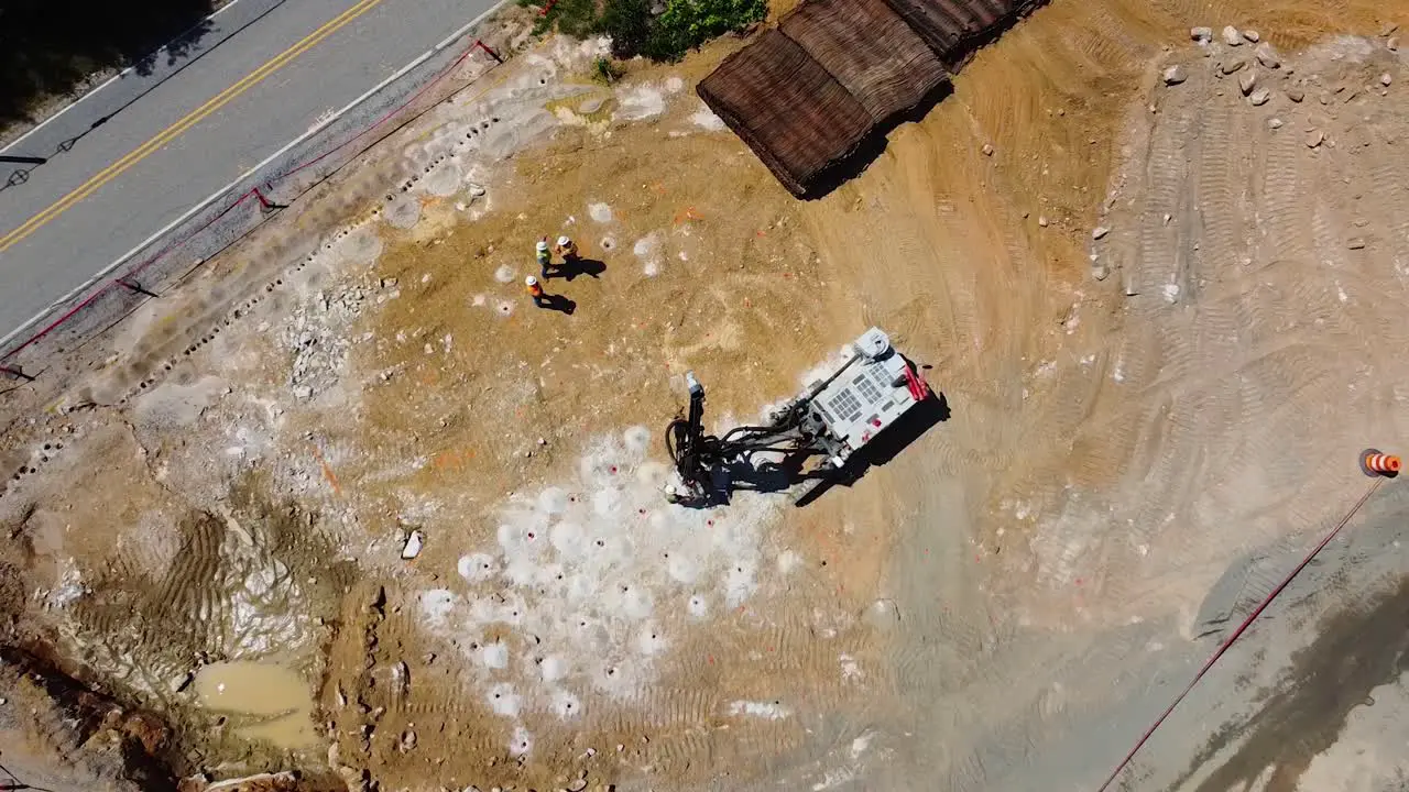 A drilling machine bores holes into the ground for explosives