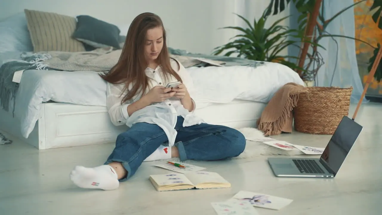 Young Artist Woman Working With A Laptop And A Smartphone