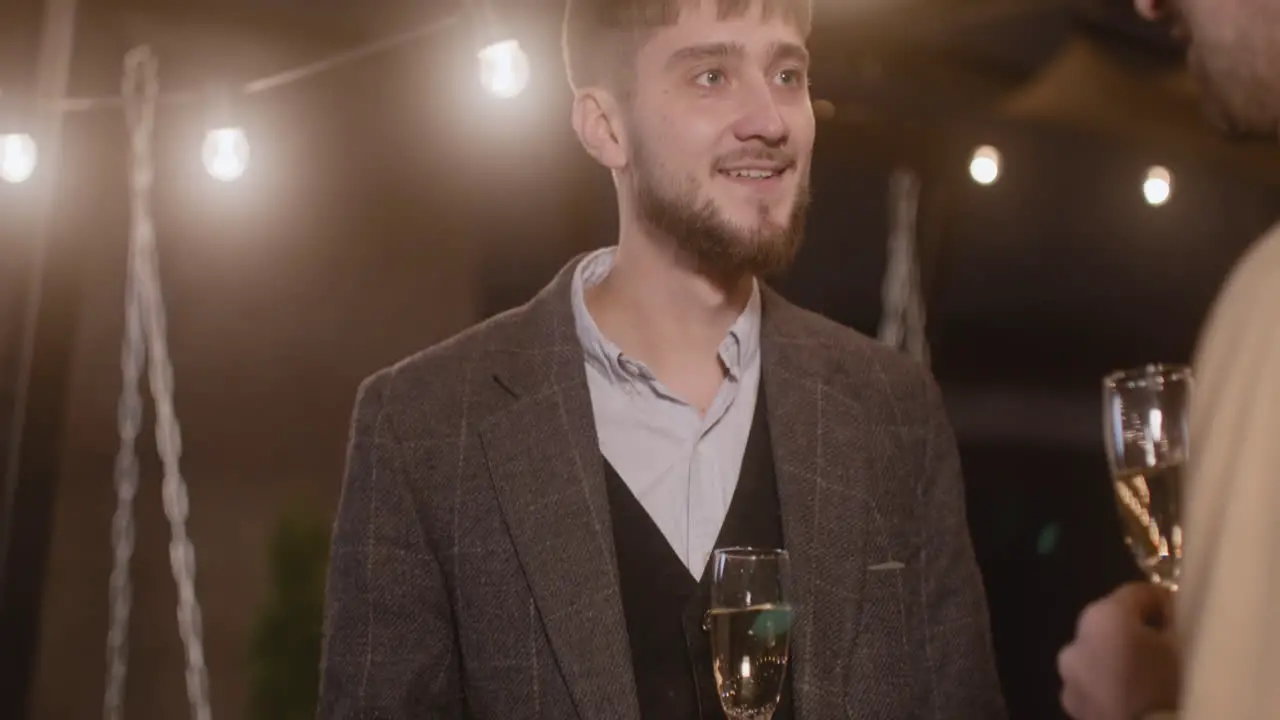 Two Elegant Men Talking To Each Other And Drinking Champagne At New Year's Eve Party 1