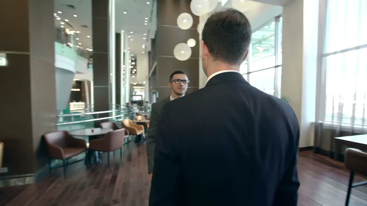 Two Businessmen Greeting Each Other In A Hotel Bar