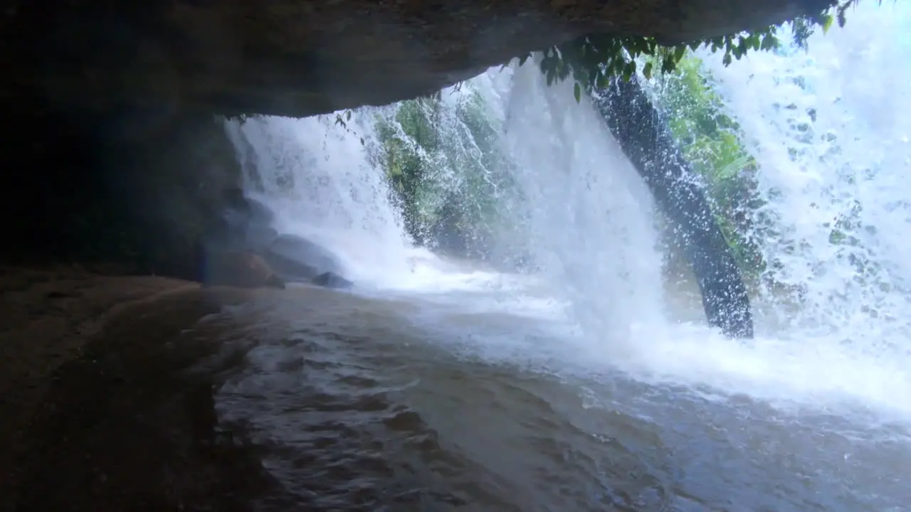 into a waterfall shot panning to showcase the falling water in slow motion in the jungle of Chiang Mai Thailand Asia in 4K downscaled to 1080p at 60fps