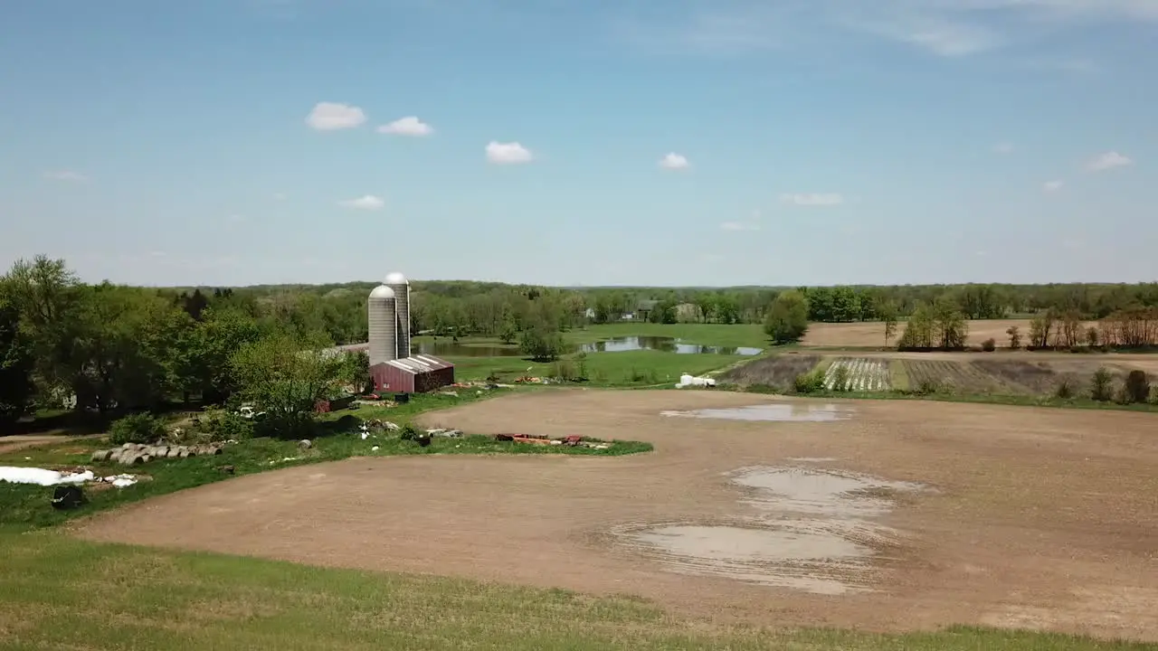 Aerial view of agricultural fields and a classic red barn with silo