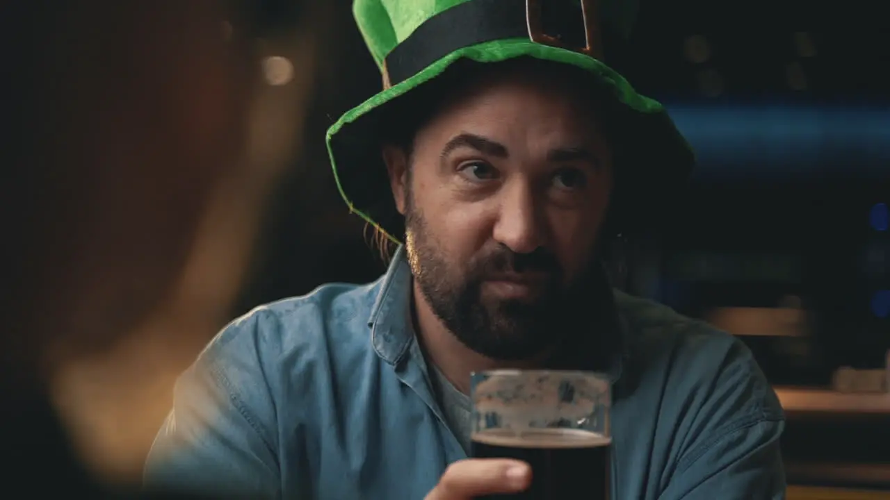 Portrait Of Man In Irish Hat Talking With Friends In A Pub