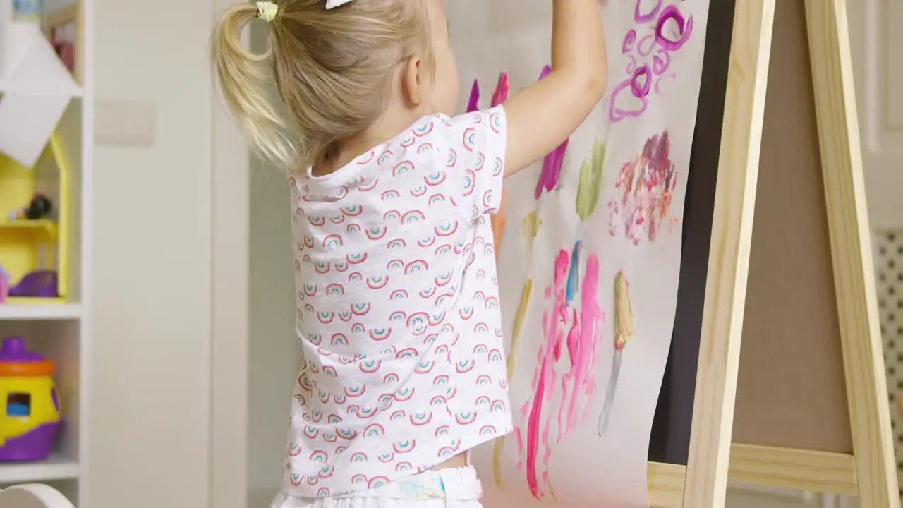 Creative little girl painting an abstract picture