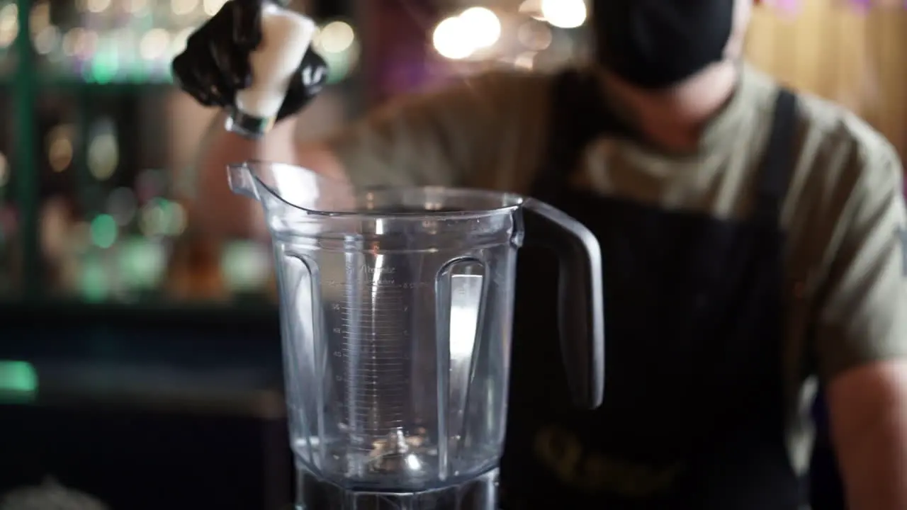 latin Bartender preparing cocktail in blender slow motion cream liqueur