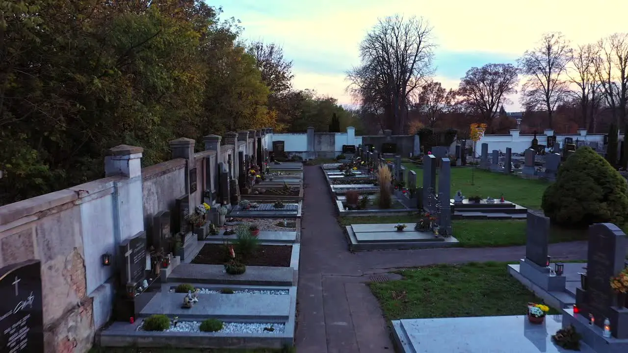 Tombstones At The Graveyard With Flowers And Lit Candles During All Saints' Day