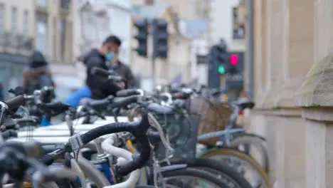 Defocused Panning Shot Revealing Bicycle Rack and City Pedestrians